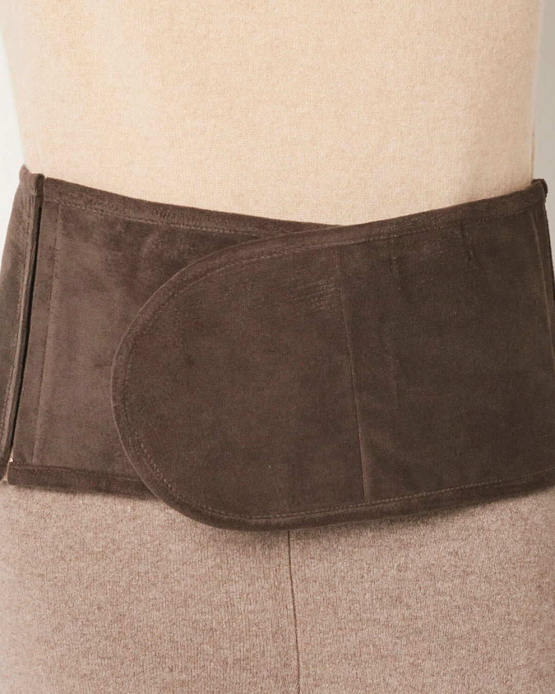 Yakuld lændebælte båret af en model, der viser, hvordan det sidder omkring lænden.