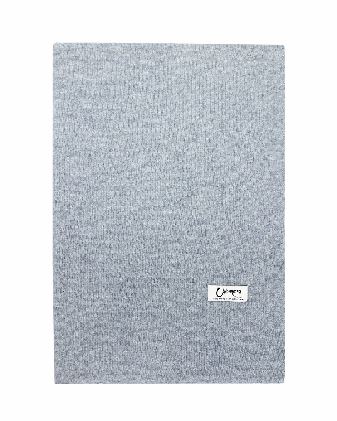 Det store tætstrikkede cashmere tørklæde i Light grey ligger fladt.