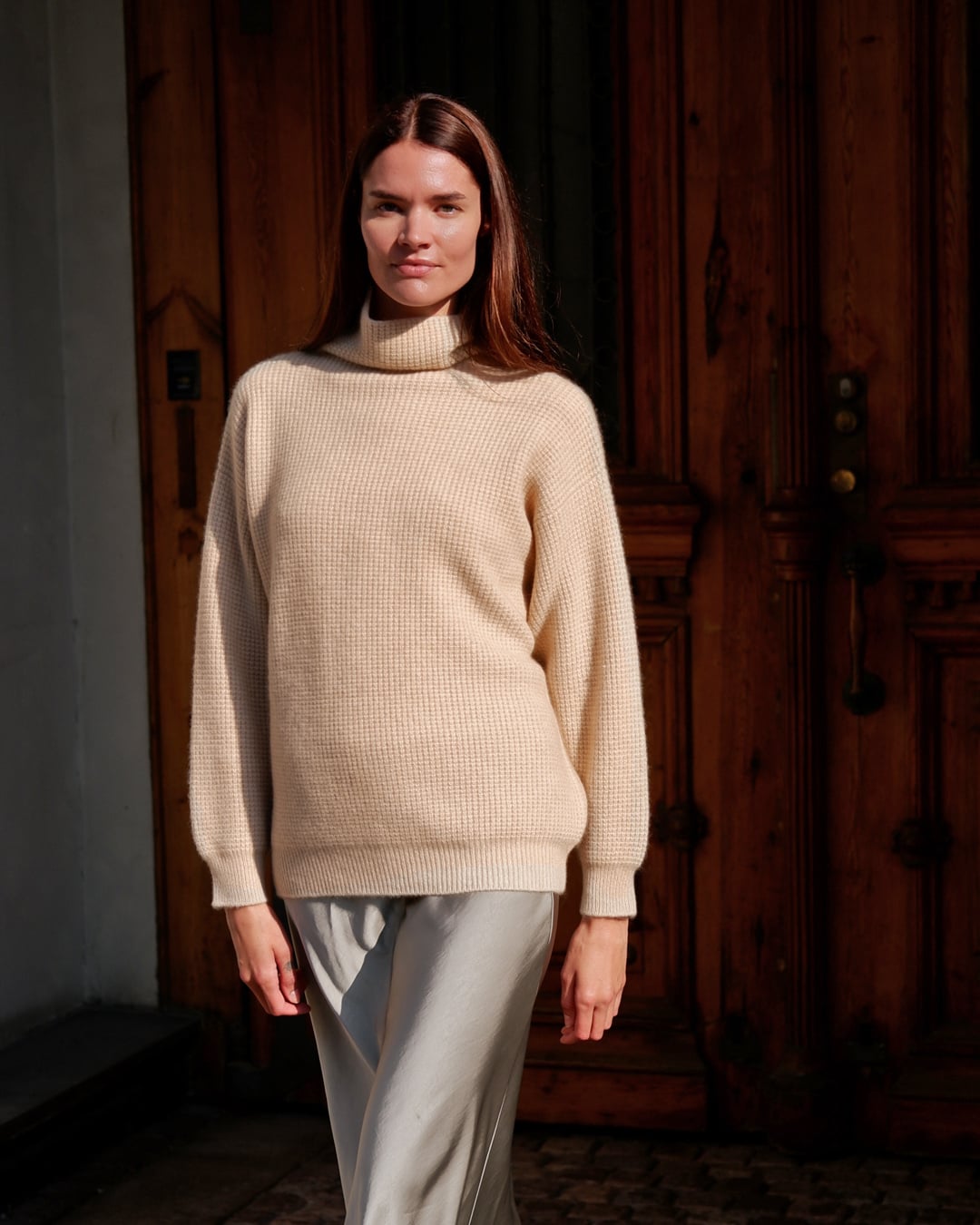 Kvinde iført Zaya turtleneck i Natural sand cashmere.