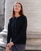 en cashmere cardigan i en sort farve stylet med et skørte