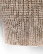 Nærbillede af strikstruktur og ribkant på ærmet, Zaya turtleneck i Natural taupe.