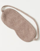 Cashmere sovemaske draperet elegant på en vandret flade.