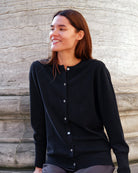 Kvinde iført Alma cardigan i Black, smilende.