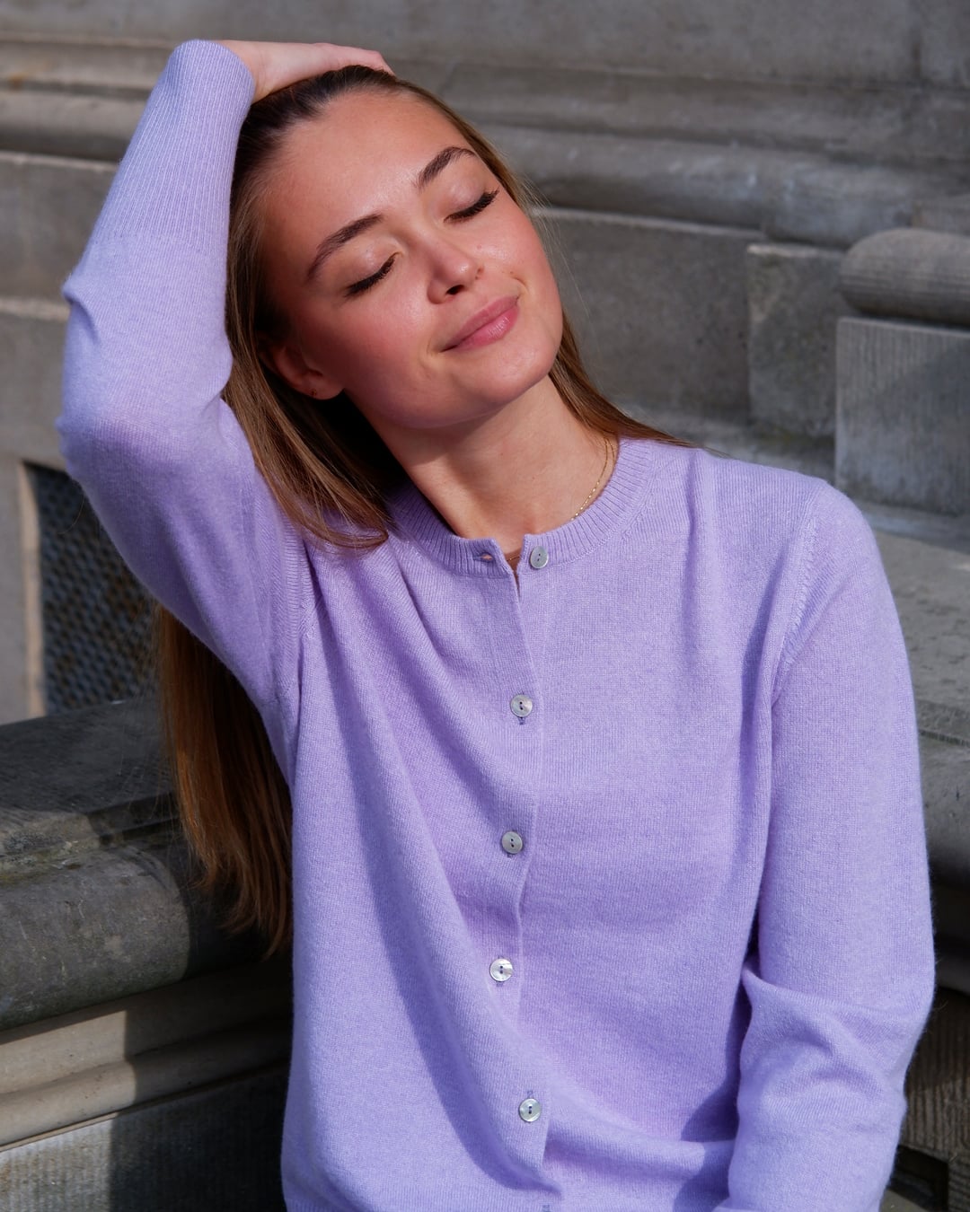 Kvinde iført Alma cardigan i Lavender, afslappet positur.