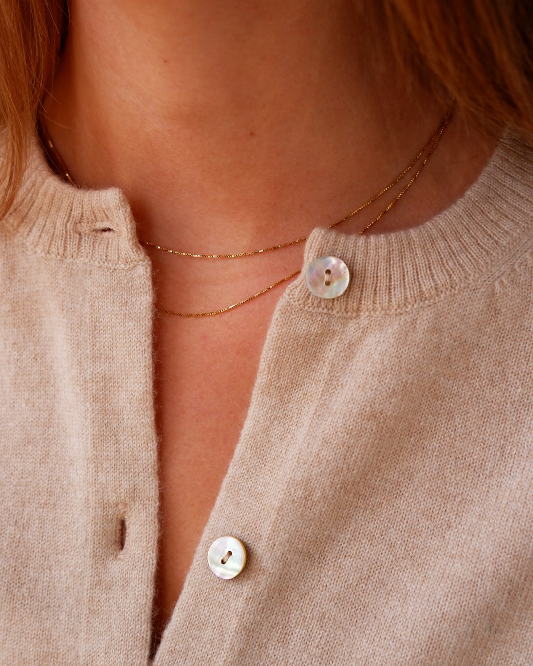 Nærbillede af Alma cardigan i Natural sand, med knapper.