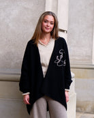 Kvinde iført sort cashmere-kappe Anu, åben model uden lukning.