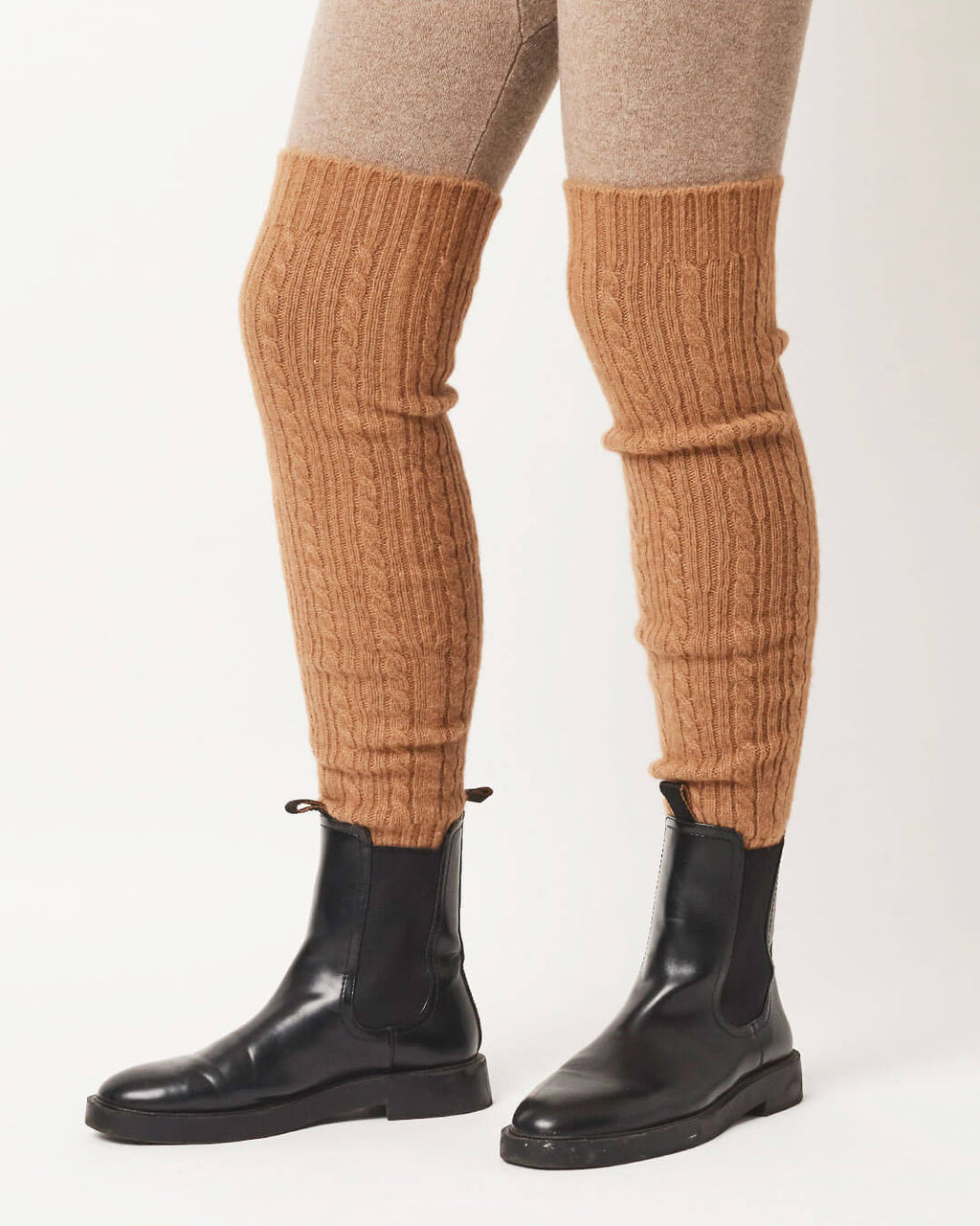 Ribstrikkede kamelulds benvarmere stylet over leggings og støvler.