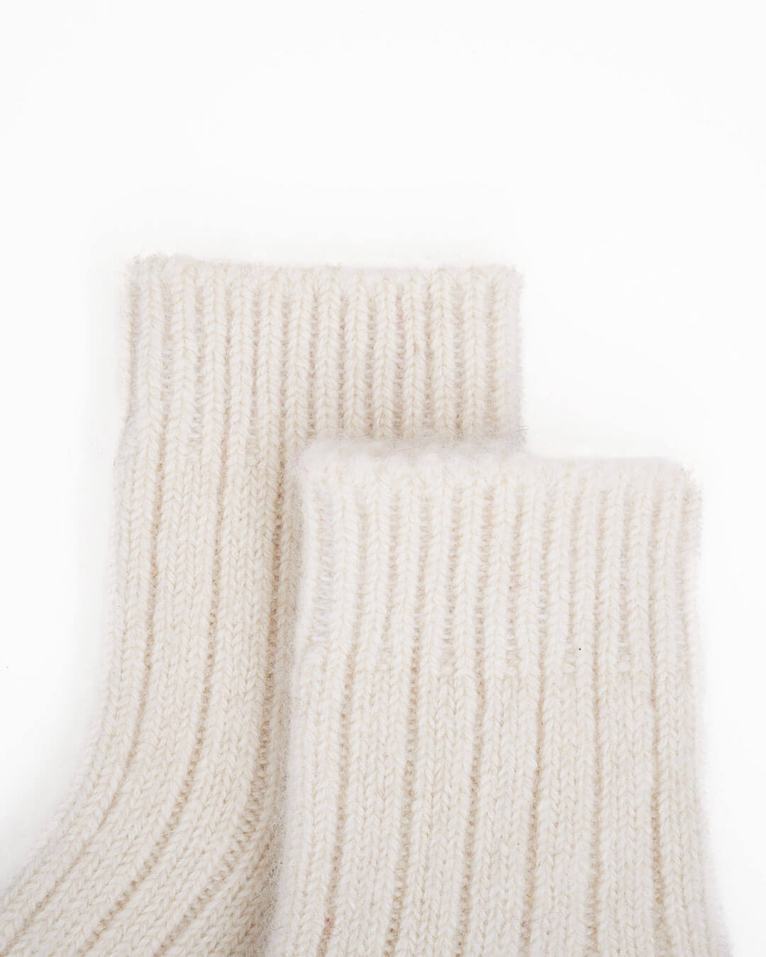 Detalje af casmere baby sokker, 0 - 12 mdr. på hvidt underlag.