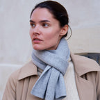 Klassisk cashmere halstørklæde i lys grå, der elegant kombinerer luksus og femininitet. Et tidløst valg til enhver garderobe.