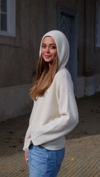 Cashmere hoodie med hætten trukket op, hvorved dens luksuriøse design fremhæves.