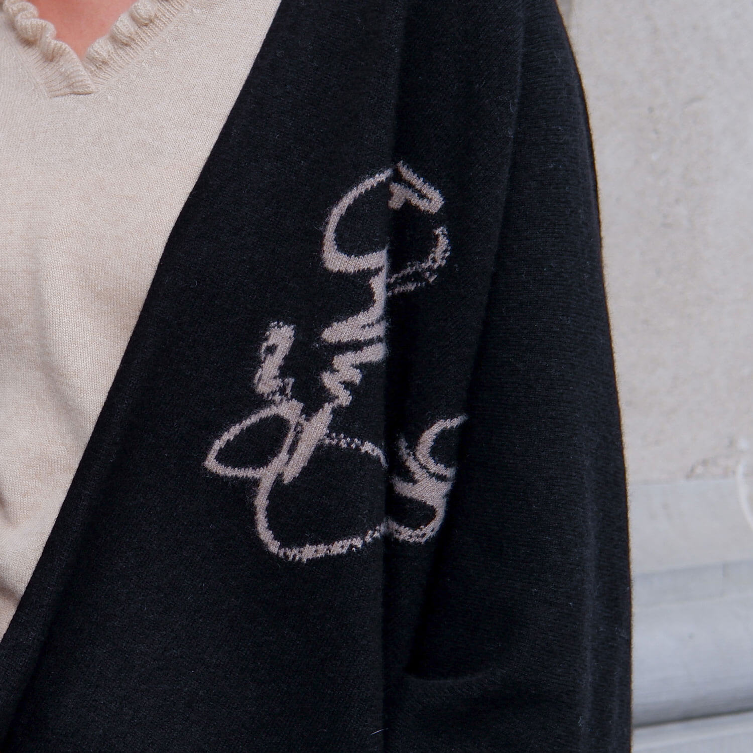 Detaljeret nærbillede af den sorte cashmere kappe med det mongolske skrifttegn.