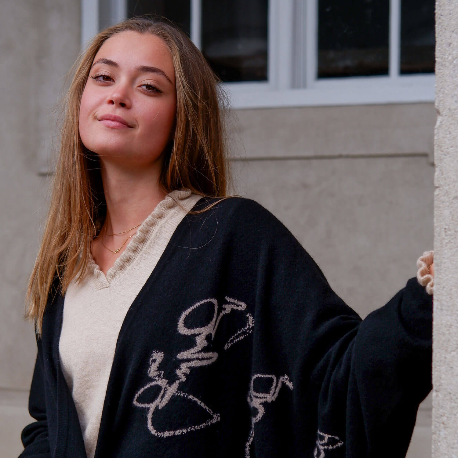 Model iført cashmere kappen, hvor man ser overdelen med det mongolske skrifttegn strikket på brystet.