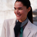 Elegant styling af cashmere Twilly-tørklædet, der smyger sig blødt om halsen i mørkegrå, lysegrå og grønne toner.