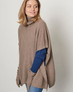 Model iført cashmere poncho med rullekrave, viser forside.