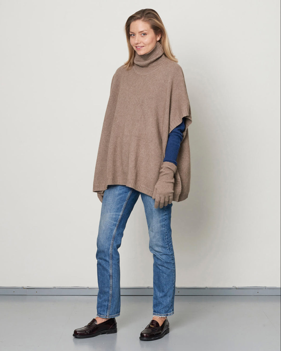 Billede af model i fuld højde med cashmere poncho med rullekrave.