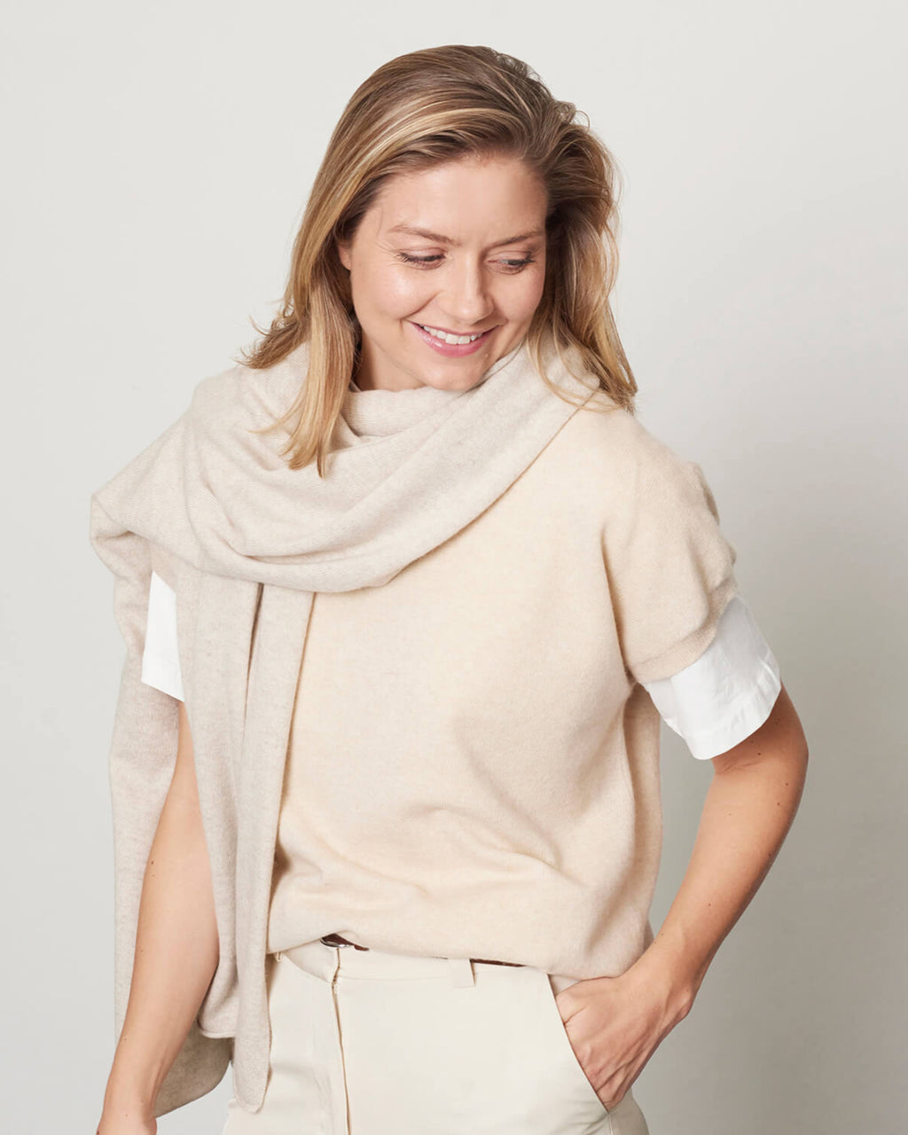 Model med det store naturfarvede cashmere tørklæde i lys gråbeige.