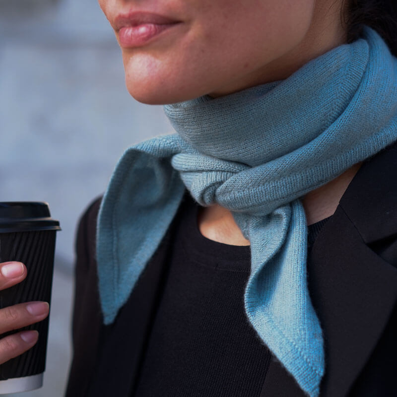 Nærbillede af trekantet cashmere tørklæde i farven Dusty Blue.