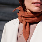 Nærbillede af trekantet cashmere tørklæde i farven Fall Brown.