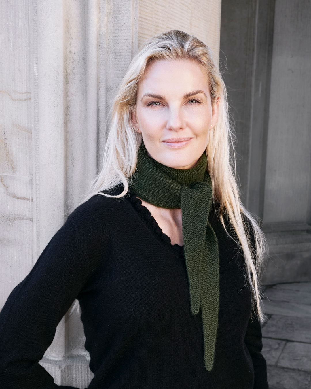 Model med Taiga cashmere trekanttørklæde i Forest green med sort bluse.