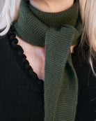 Taiga cashmere trekanttørklæde i Forest green – close-up af rillestrik ved halsen.