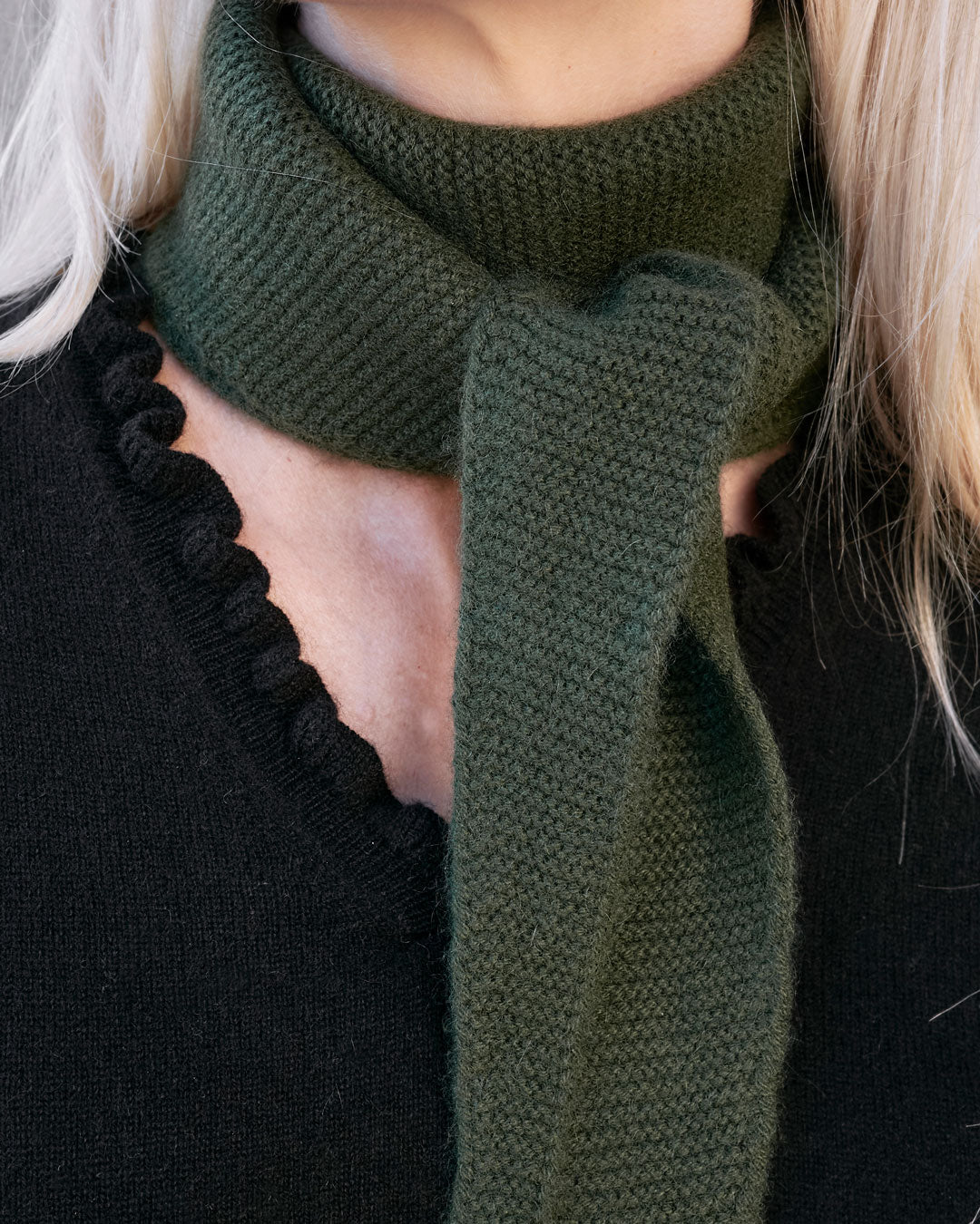 Taiga cashmere trekanttørklæde i Forest green – close-up af rillestrik ved halsen.