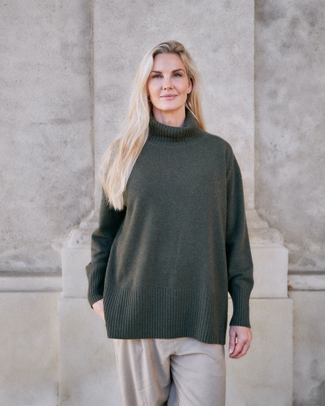 Model iført klassisk cashmere sweater med sadelskuldre og løs pasform i army green