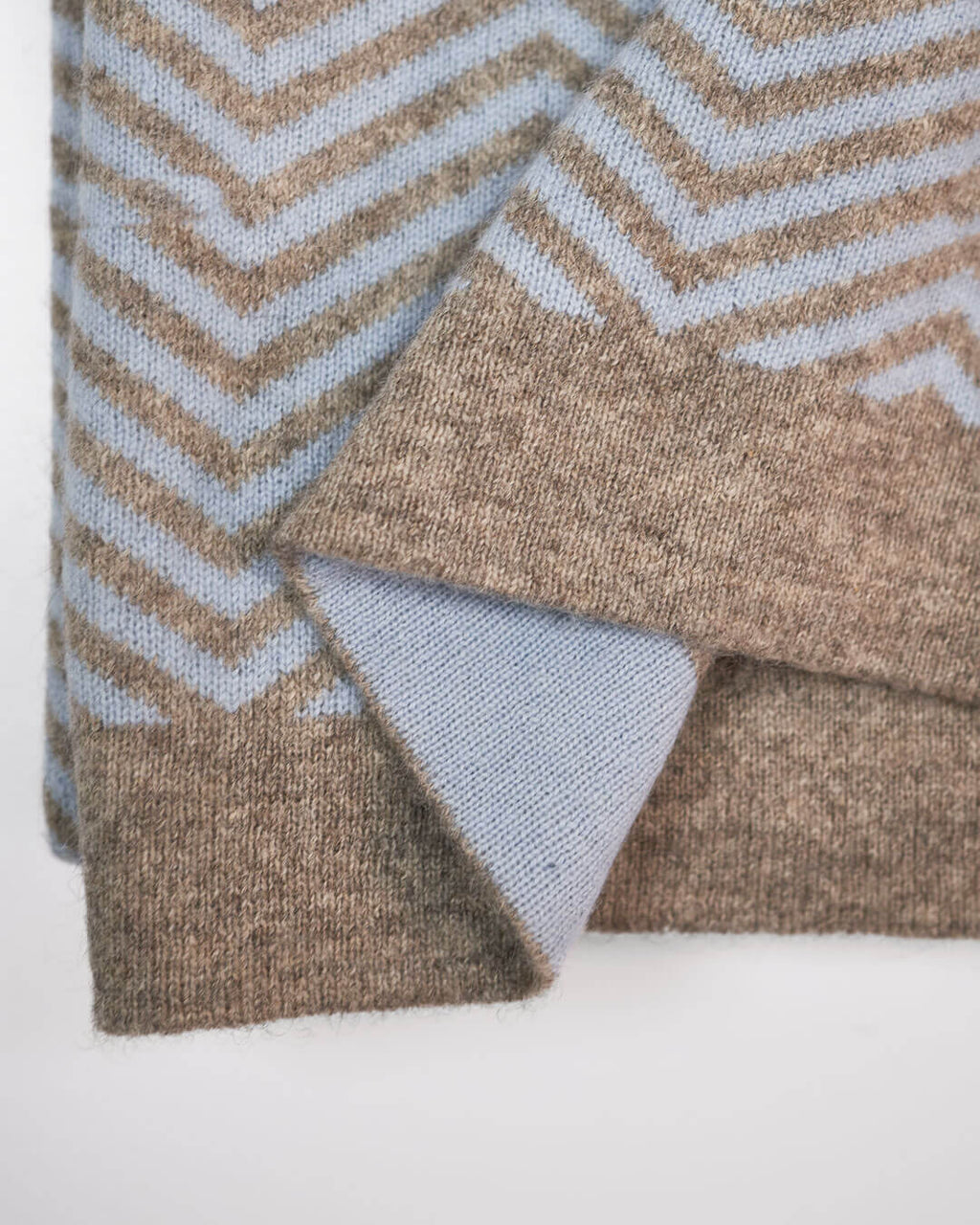 Detalje af plaid i cashmere og yakuld, hvor man ser den platingrå yakuld kant  og ice blue cashmere på den modsatte side. 