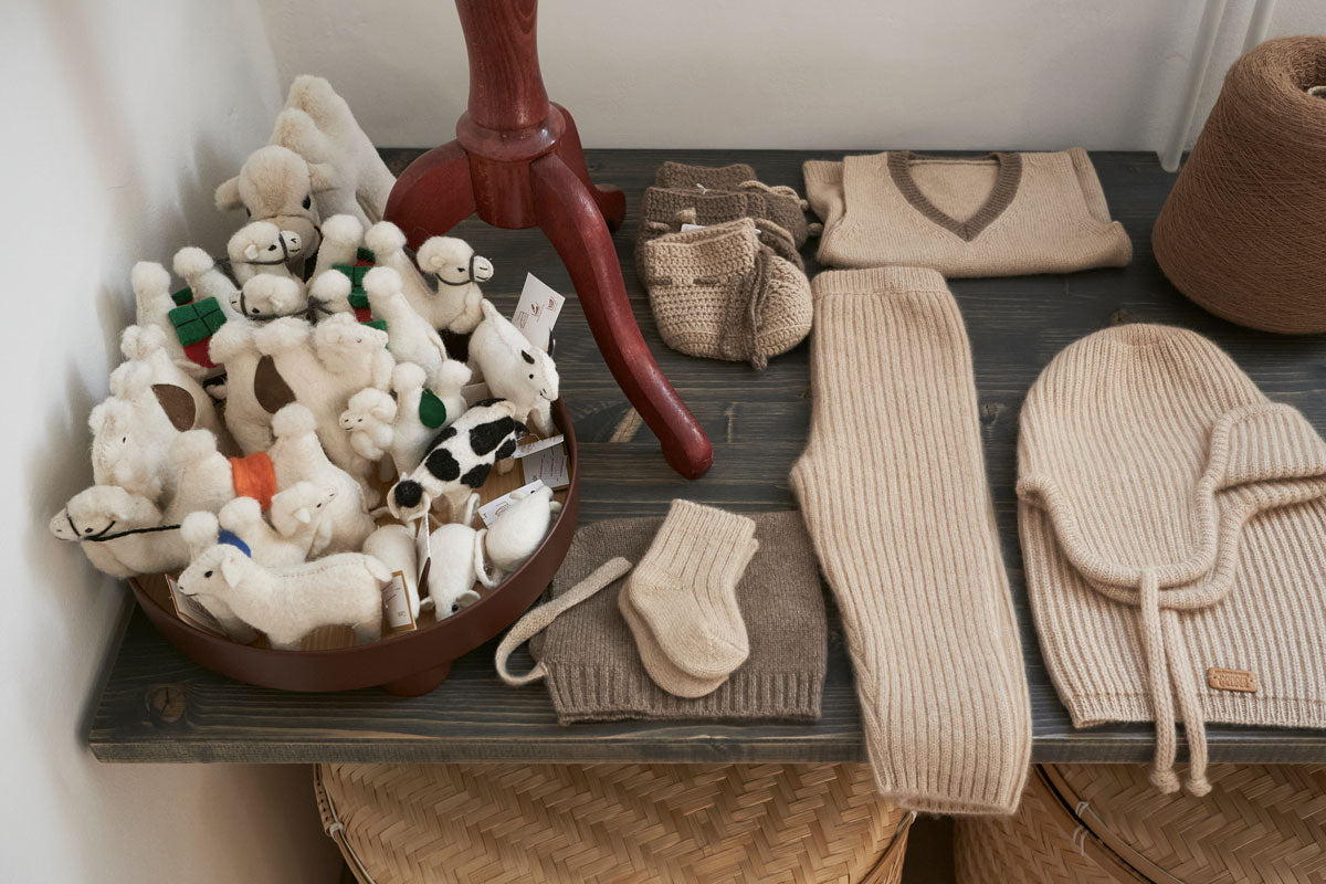 Strikkede babyprodukter og uldfiguriner udstillet i Undarmaa showroom