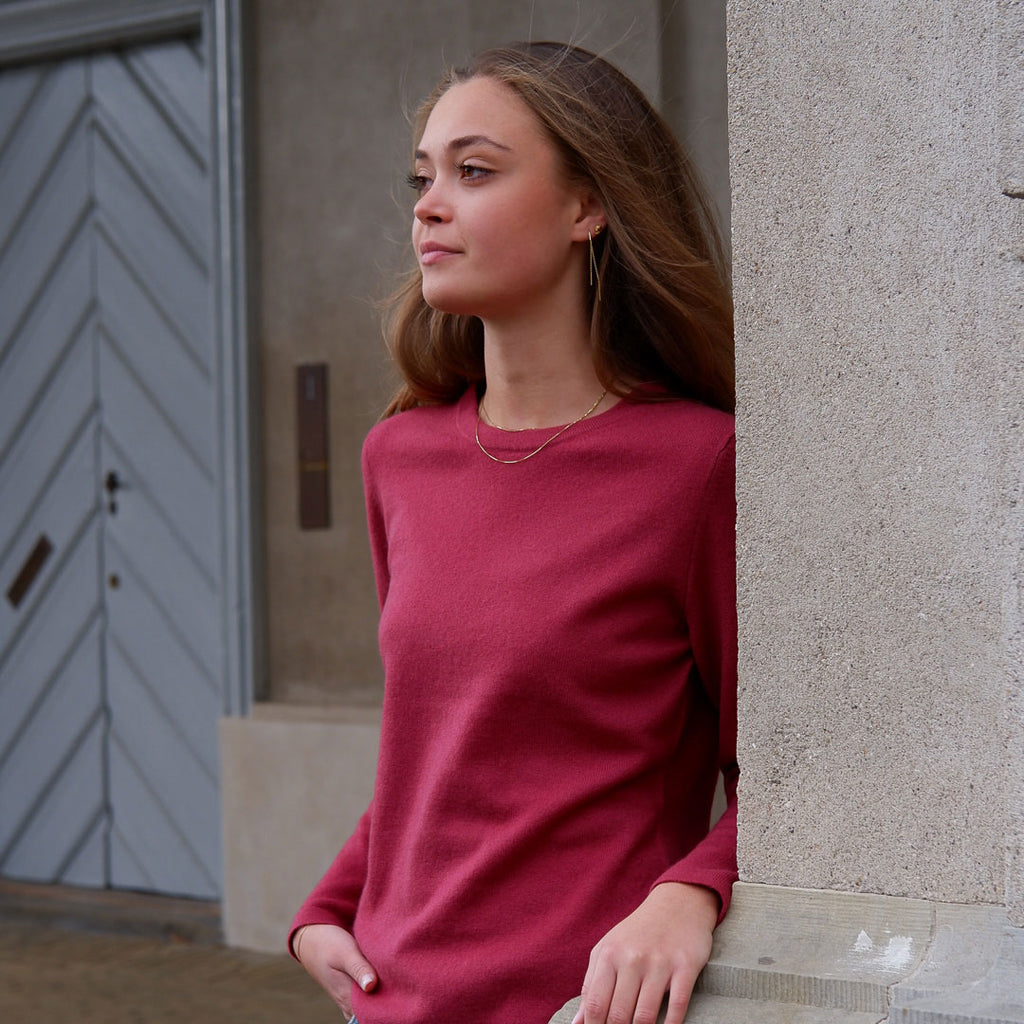 Model iført Nomen Cashmere Crewneck, Pinot Red, med naturligt lys.