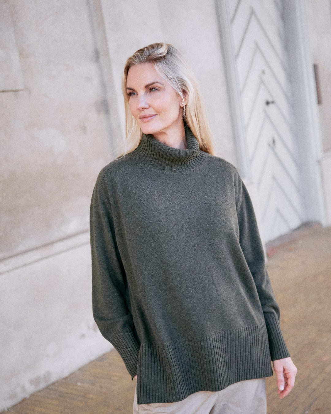 Dolgoon tunika i olive green med høj rullekrave, vist på model