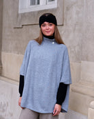 Kvinde iført cashmere poncho Enkh i Light grey med høj hals og knapper.