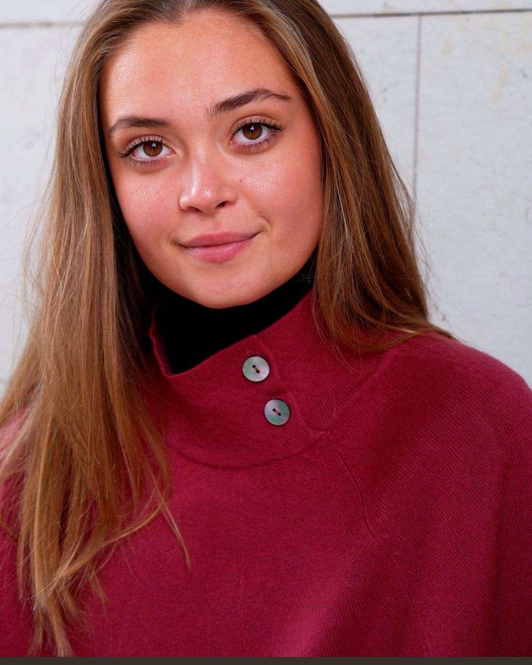 Nærbillede af halskrave og knapper på cashmere poncho Enkh i Raspberry.
