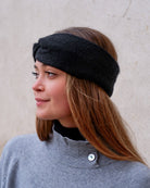 Model iført cashmere pandebånd i Black set fra siden.