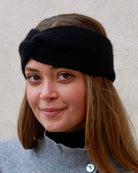 Model iført cashmere pandebånd i Black set forfra.