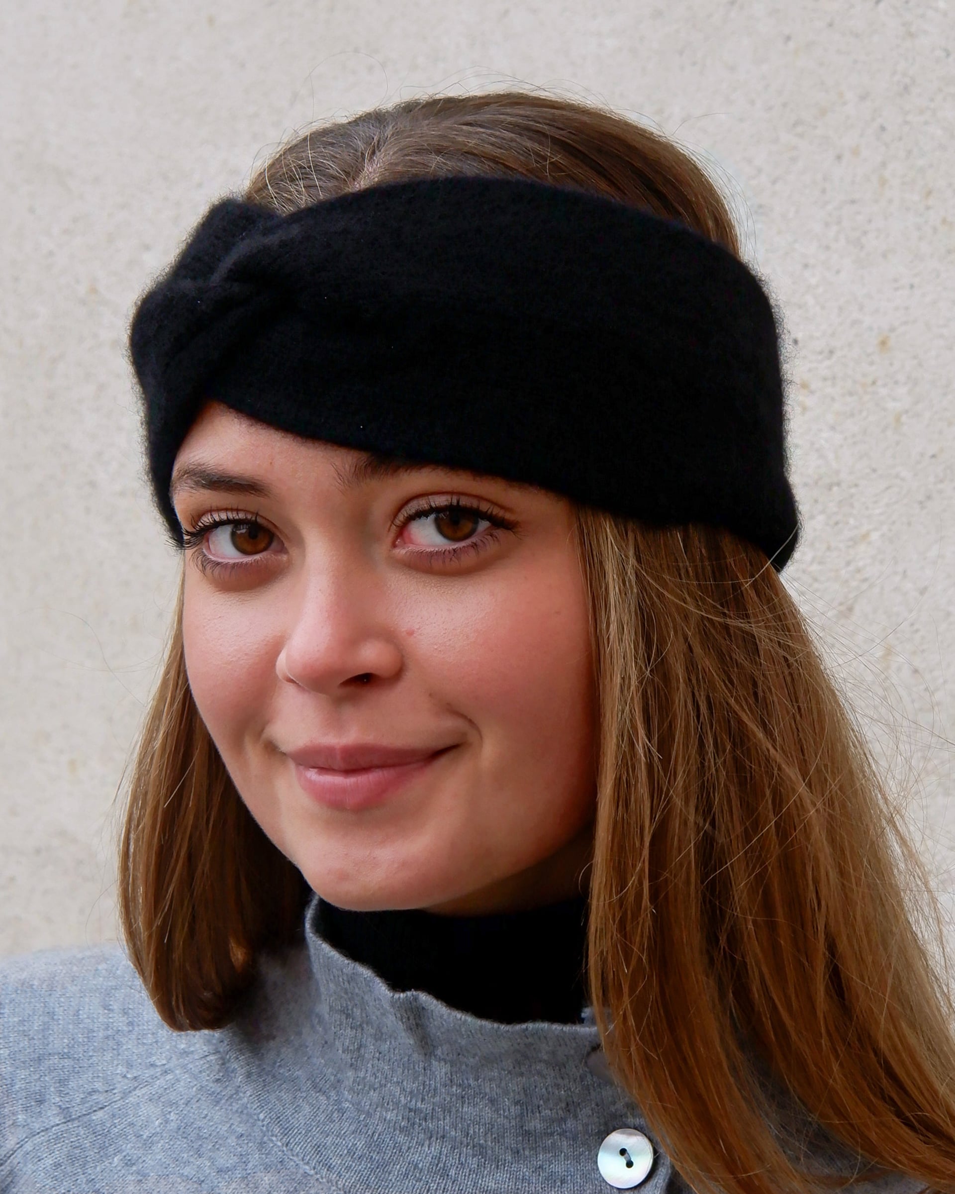 Model iført cashmere pandebånd i Black set forfra.