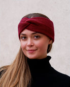 Model iført cashmere pandebånd i Bordeaux set forfra.
