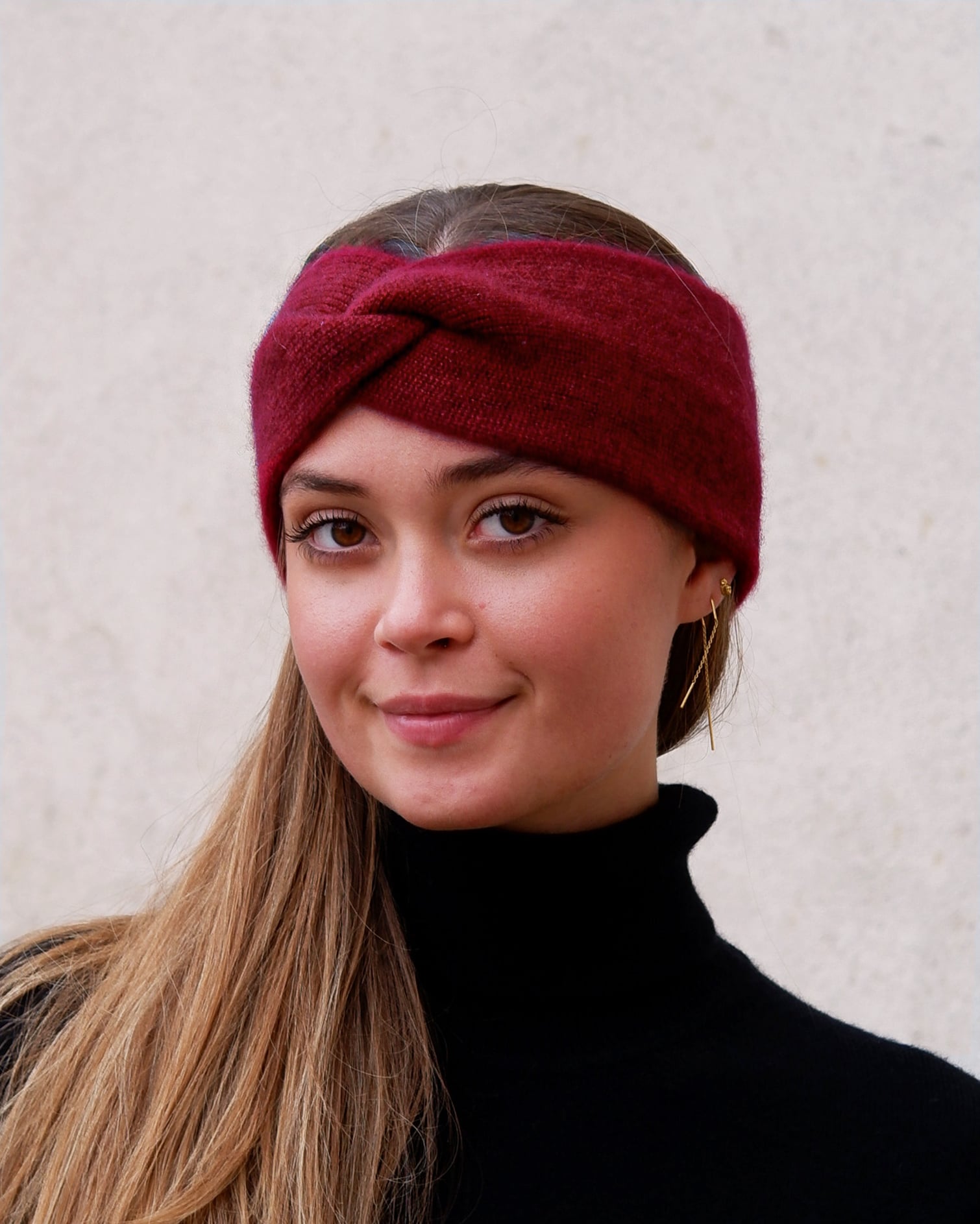 Model iført cashmere pandebånd i Bordeaux set forfra.