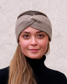 Model iført cashmere pandebånd i Natural taupe set forfra.