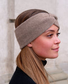 Model iført cashmere pandebånd i Natural taupe set fra siden.