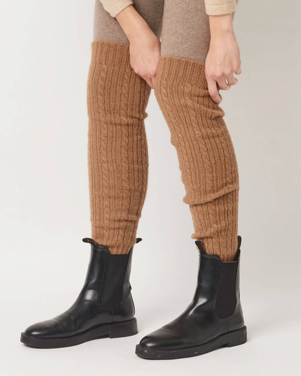 Model er iklædt benvarmere i 100% kameluld i den naturlige brune kameluldsfarve