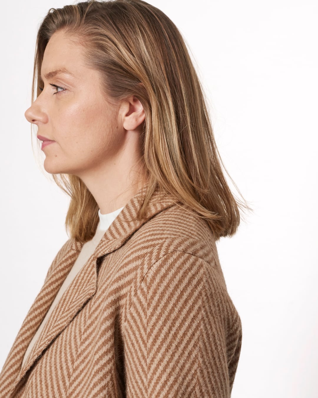Nærbillede af sildebensmønsteret i kameluldsfrakken Khongor, set i profil.