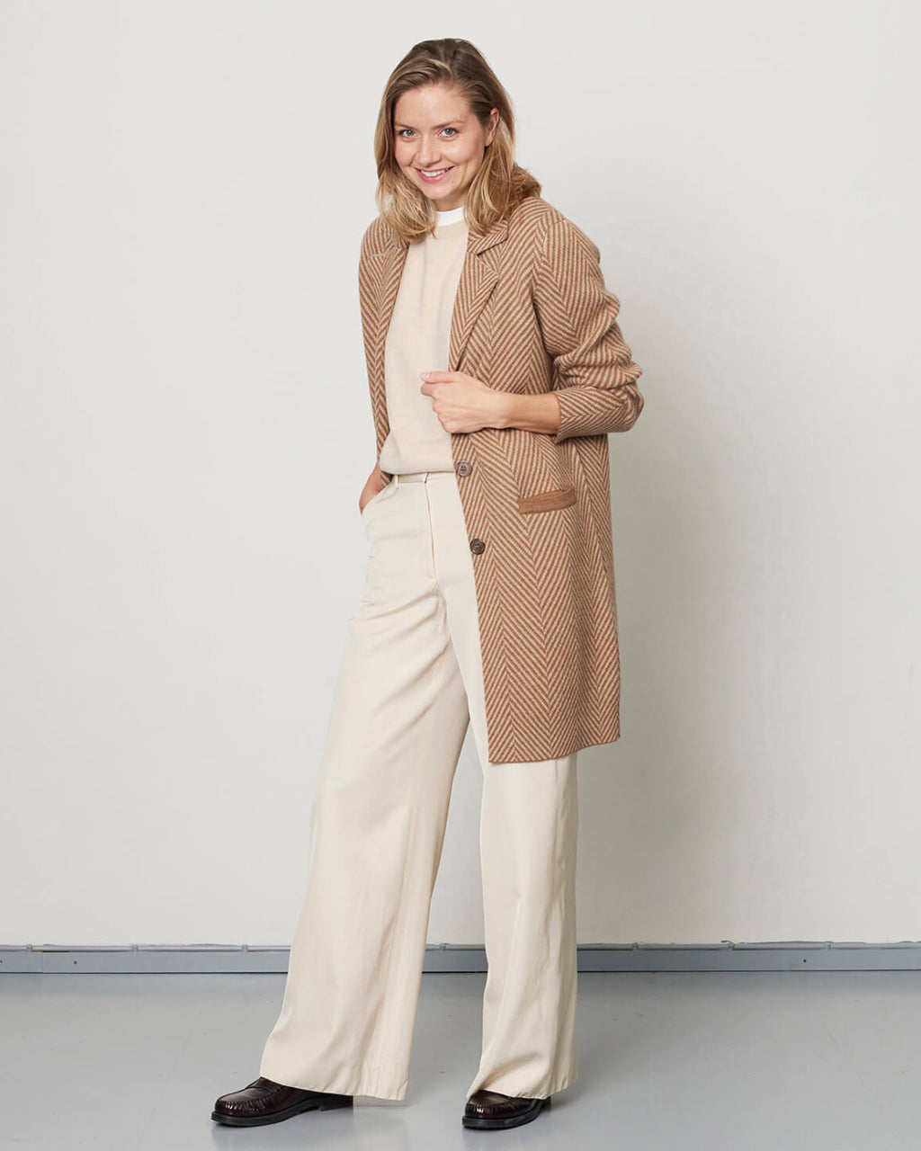 Model iført den klassiske kameluld frakke i hel figur fra Undarmaa 