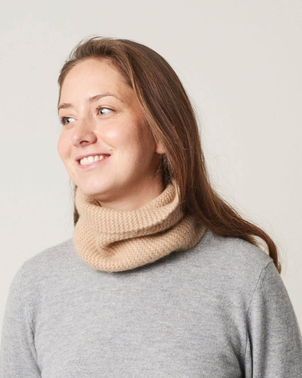 Kamelulds halsedisse båret af model, hvor man kan se den lyse naturlige farve og tekstur.