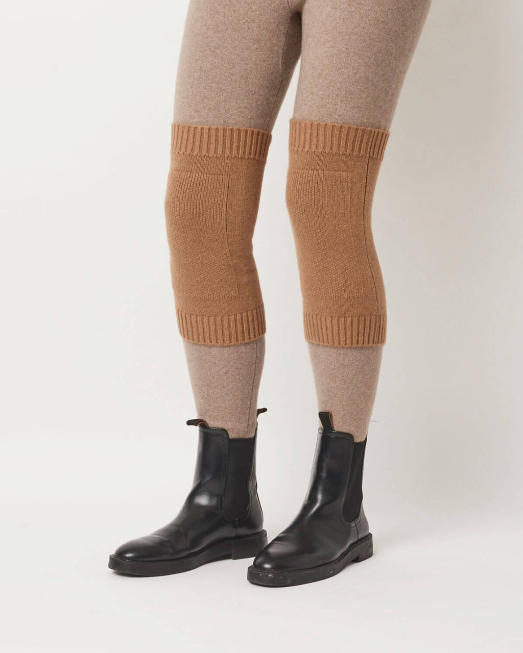 Model viser kameluld knævarmere, der diskret og komfortabelt støtter knæene..
