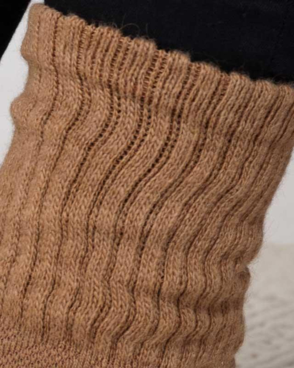 Nærbillede af kameluldsokker i naturlig farve, der viser den fine strik og farvenuancer.