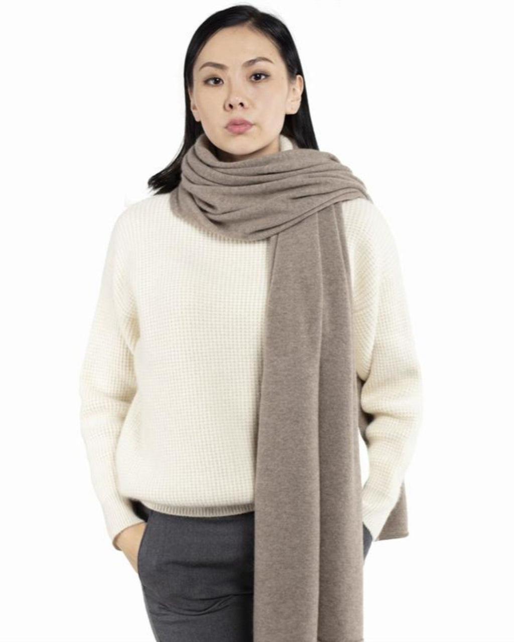 Model med det store naturfarvede cashmere tørklæde i mørk gråbeige svøbt om halsen.