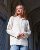 Kvinde iført Namuun hoodie i Natural white, hætte på, positur.