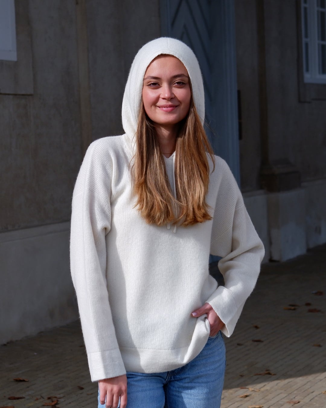 Kvinde iført Namuun hoodie i Natural white, hætte på.
