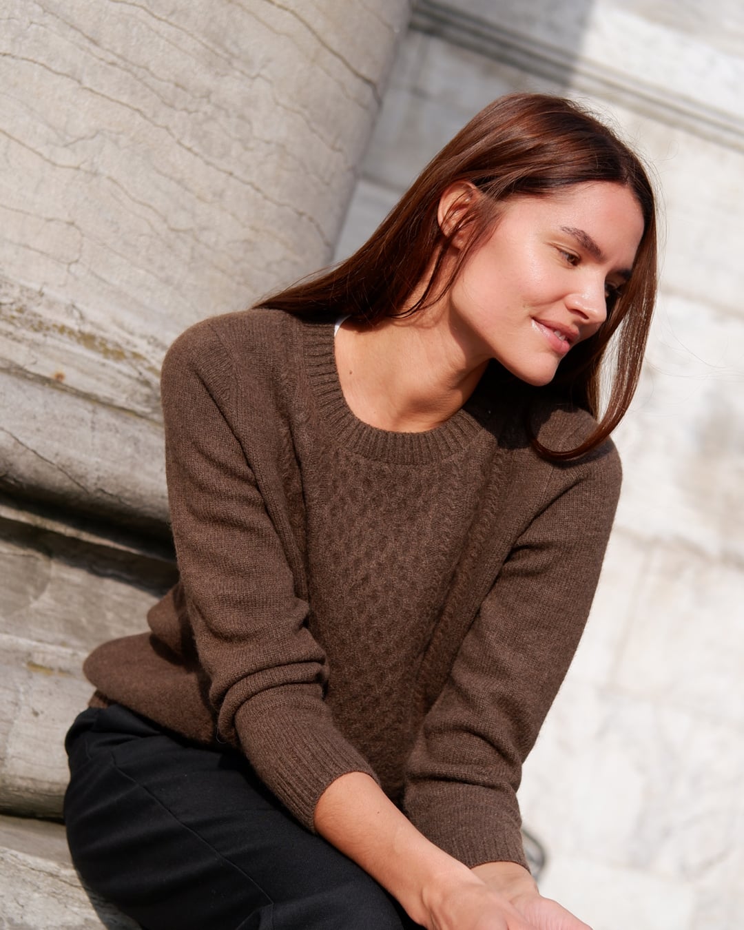 Kvinde iført Naran bluse i Natural light brown, siddende, kigger ned.