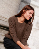 Kvinde iført Naran bluse i Natural light brown, siddende, kigger ned.